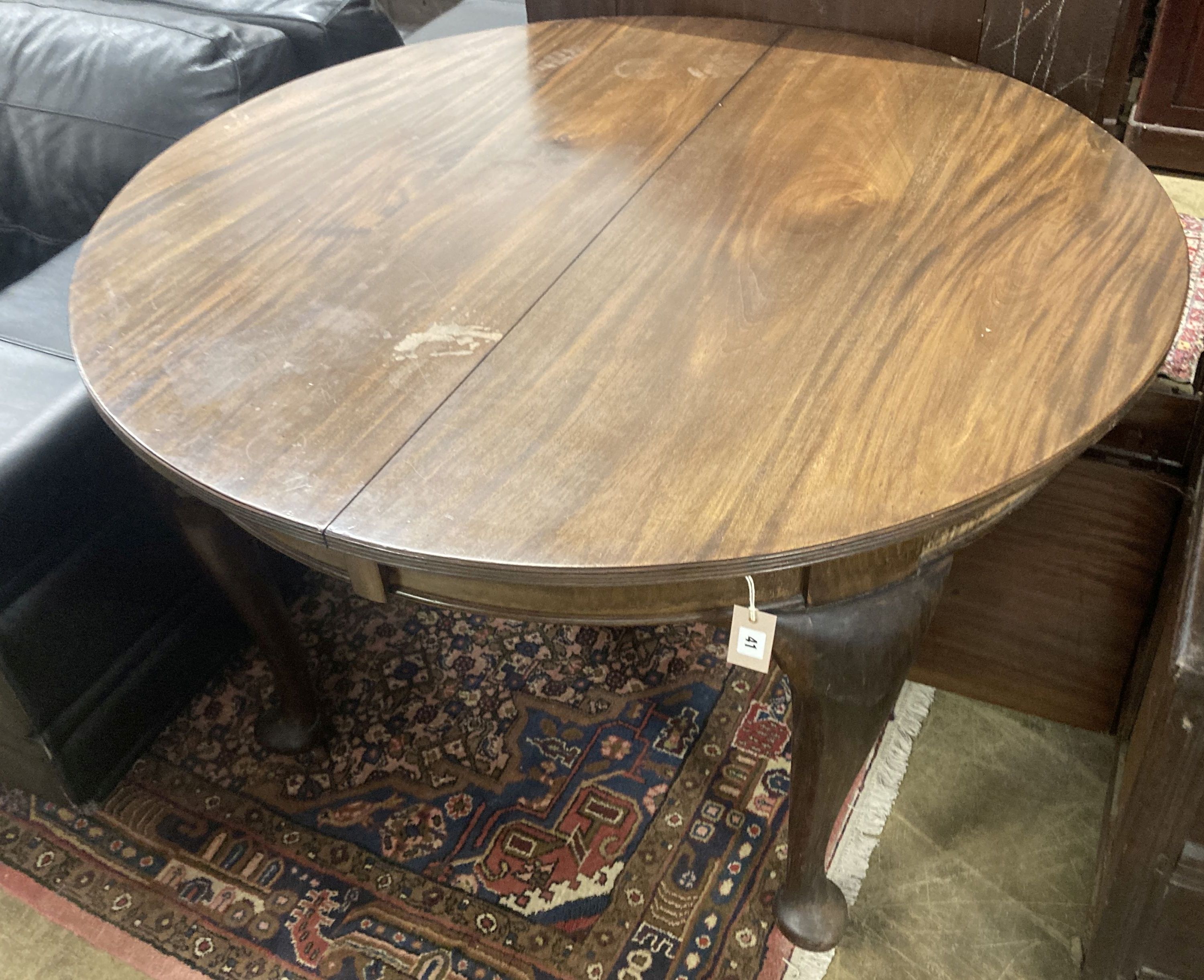 A 1920's circular mahogany extending dining table with three leaves and handle, length approx. 230cm extended, width 120cm, height 75cm